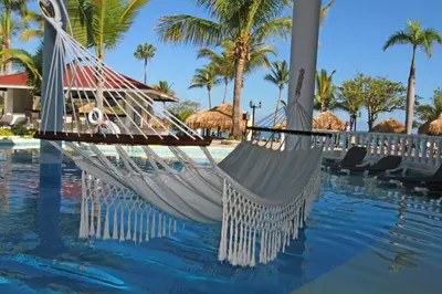 a hammock by the pool at a resort at Cofresi Palm Beach & Spa Resort - All Inclusive in San Felipe de Puerto Plata