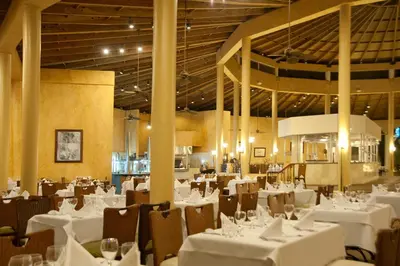 a dining room filled with white tables and chairs at Cofresi Palm Beach & Spa Resort - All Inclusive in San Felipe de Puerto Plata