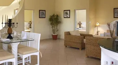 a living room with a table and chairs and a couch at Lifestyle Crown Residence Suites in San Felipe de Puerto Plata