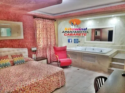 a hotel room with a bed and a bath tub at Kitewind Apartamentos Cabarete in Cabarete