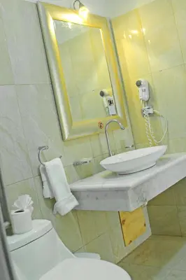 a bathroom with a sink and a toilet and a mirror at Kitewind Apartamentos Cabarete in Cabarete