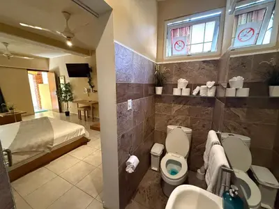 a bathroom with a bed and a toilet and a sink at Sosua Inn Hotel in Sosúa