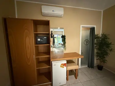 a kitchen with a counter and a table and a refrigerator at Sosua Inn Hotel in Sosúa