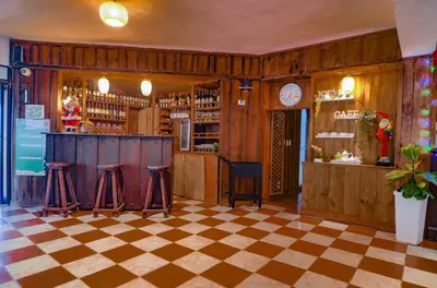 a bar with a checkered floor and stools at Hotel Rancho Constanza & Cabañas de la Montaña in Constanza
