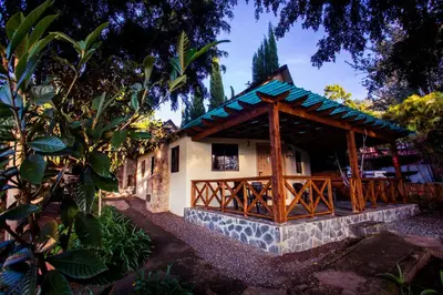 a house with a wooden pavilion in a garden at Hotel Rancho Constanza & Cabañas de la Montaña in Constanza