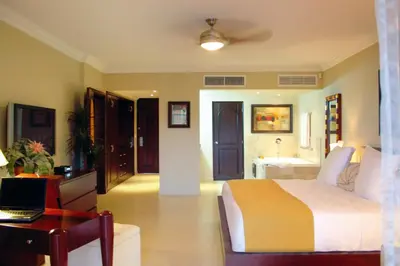 a bedroom with a bed and a desk with a laptop at Presidential Suites by Lifestyle Puerto Plata - All Inclusive in San Felipe de Puerto Plata