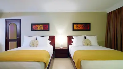 two beds in a hotel room with two at Presidential Suites by Lifestyle Puerto Plata - All Inclusive in San Felipe de Puerto Plata