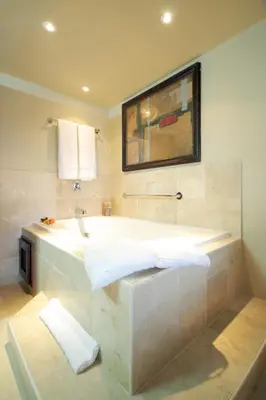 a large bathroom with a tub and a painting on the wall at Presidential Suites by Lifestyle Puerto Plata - All Inclusive in San Felipe de Puerto Plata
