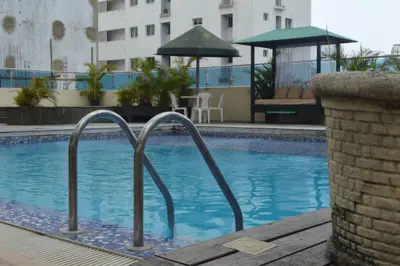 a swimming pool with two metal rails in a building at Golden House Hotel & Convention Center in Santo Domingo