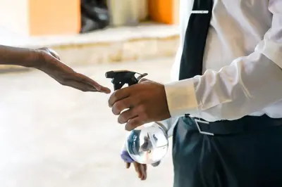 a man in a suit and tie is looking at his watch at Golden House Hotel & Convention Center in Santo Domingo