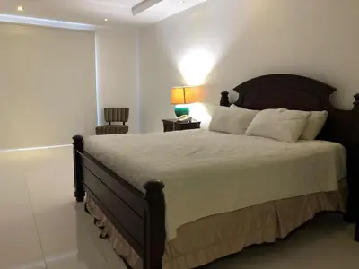 a bedroom with a large bed and a lamp at Golden House Hotel & Convention Center in Santo Domingo