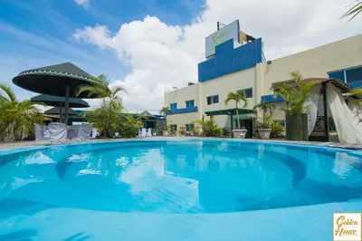 a large blue swimming pool in front of a building at Golden House Hotel & Convention Center in Santo Domingo