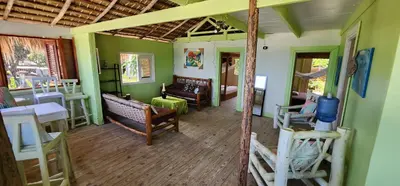 a living room with green walls and wooden floors at Tropic ecolodge in Punta Rucia