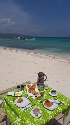 a table with plates of food on the beach at Tropic ecolodge in Punta Rucia
