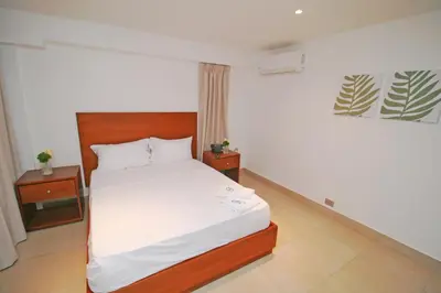 a bedroom with a bed and two night stands at Palmetto Hotel in Santiago de los Caballeros