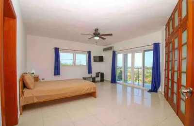 a bedroom with a bed and a ceiling fan at Hispaniola Residencial private villas in Sosúa