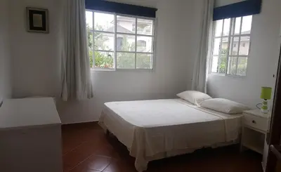 a white bedroom with a bed and two windows at Hispaniola Residencial private villas in Sosúa
