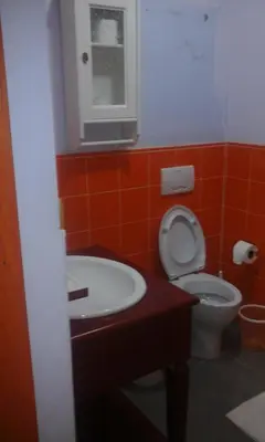 a bathroom with a toilet and a sink and a window at Residencial Las Estrellas in Boca Chica