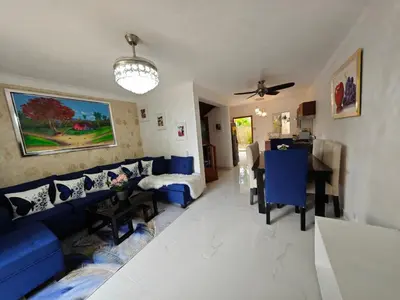 a living room with a blue couch and a table at Residencial Las Estrellas in Boca Chica