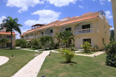 a large building with palm trees in front of it at Residencial Las Estrellas in Boca Chica