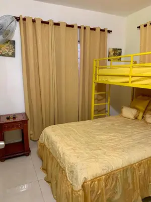 a bedroom with a yellow bunk bed and a table at Higuey Center City in Higuey