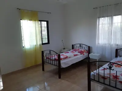 a bedroom with two bunk beds and two windows at Caleton Group in Río San Juan