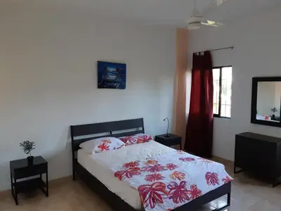 a bedroom with a bed and two tables and a mirror at Caleton Group in Río San Juan