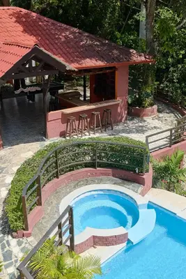 a small swimming pool with a table and a house at Villa Bayacanes con piscinas privadas in Jarabacoa