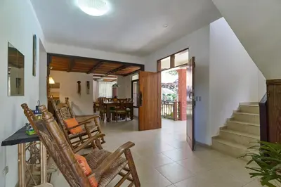 a living room with rocking chairs and a staircase at Villa Bayacanes con piscinas privadas in Jarabacoa