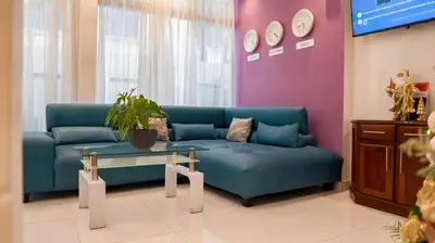 a living room with a blue couch and a table at Cataleya Hotel in Santo Domingo
