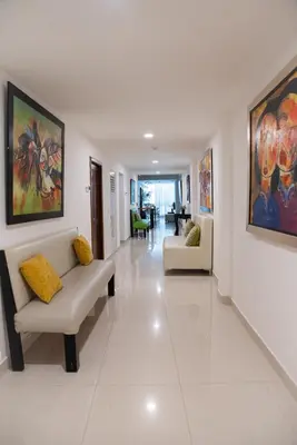 a living room with couches and paintings on the walls at Cataleya Hotel in Santo Domingo