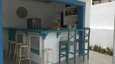 a bar with stools and a blue counter in a room at B&B Villa Luna in Bayahibe