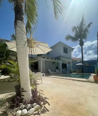 a house with a palm tree and a swimming pool at B&B Villa Luna in Bayahibe