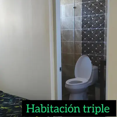 a bathroom with a toilet and a tile wall at La Ensenada Boutique Hotel in Punta Rucia