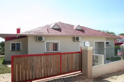 a house with a red fence in front of it at Villas Michaela Caribbean in Sosúa