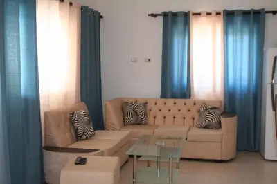 a living room with a couch and blue curtains at Villas Michaela Caribbean in Sosúa
