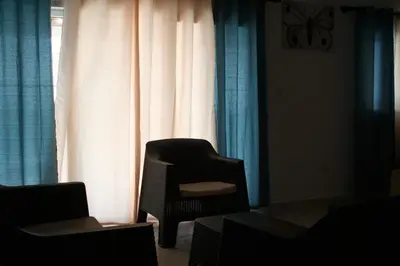 a chair sitting in front of a window with curtains at Villas Michaela Caribbean in Sosúa