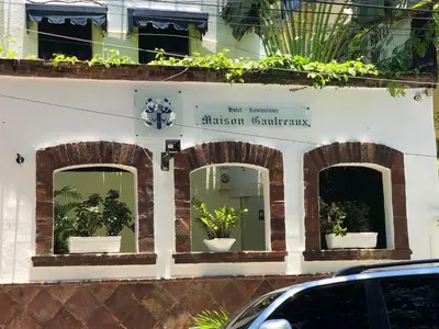 a building with three windows with potted plants on it at Hotel Maison Gautreaux in Santo Domingo