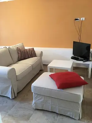 a living room with a couch and a table with a laptop at Casita Blanca Bayahibe in Bayahibe