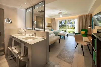 a bathroom with a sink and a living room at Catalonia Bayahibe - All Inclusive in Bayahibe