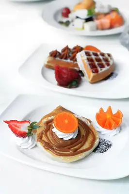 a plate of food with waffles and fruit on it at Barceló Santo Domingo in Santo Domingo