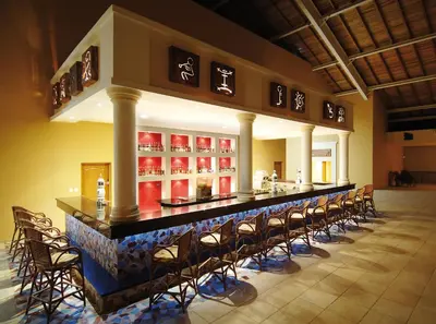a bar in a restaurant with a bunch of chairs at Occidental Caribe - All Inclusive in Punta Cana