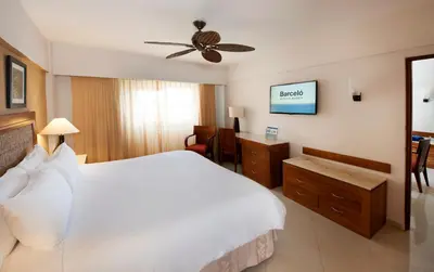 a bedroom with a white bed and a ceiling fan at Occidental Caribe - All Inclusive in Punta Cana