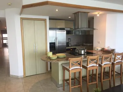 a kitchen with a island with chairs and a counter top at Marbella Juan Dolio in Juan Dolio