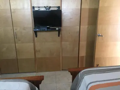 a living room with a tv and a cabinet at Marbella Juan Dolio in Juan Dolio