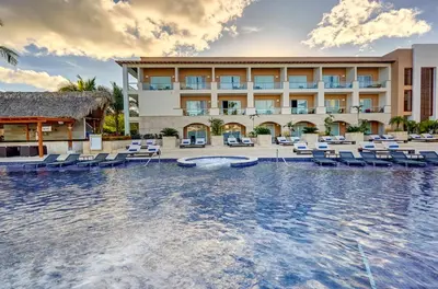 a resort with a pool and chairs and a building at Royalton Hideaway Punta Cana, An Autograph Collection All-Inclusive Resort & Casino - Adults Only in Punta Cana