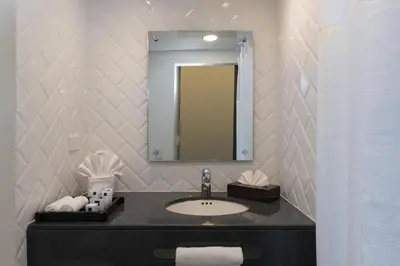 a bathroom with a sink and a mirror at Novus Plaza Hodelpa in Santo Domingo
