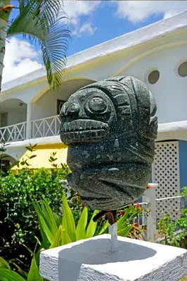 a statue of a head in front of a house at Le BDM PLAYITA in Las Galeras