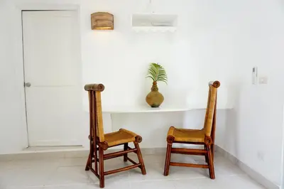 two wooden chairs sitting in a room with a shelf at Le BDM PLAYITA in Las Galeras