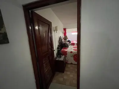 a door leading to a bedroom with a person sitting on a bed at Villa Antonia 16 in Sosúa